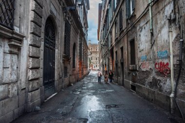 ROME, ITALY - 15 HAZİRAN 2025: Eski Roma 'da harap olmuş, grafiti kaplı sokak kentsel çürümeyi, duvarları ve tarihi mimariyi ön plana çıkarıyor..