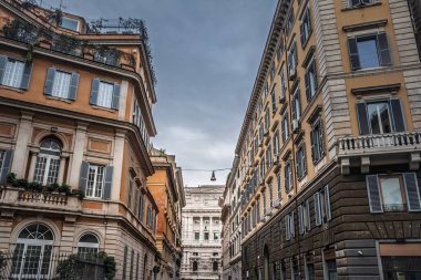 Roma, İtalya 'da geleneksel konut binalarıyla dolu bir caddenin aşağısına bakın, tarihi kent mimarisini ve şehir merkezindeki tipik gayrimenkulleri vurguluyor..