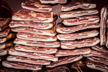 Sırbistan 'ın kırsal kesimindeki bir pazarda kurutulmuş domuz etinden yapılmış ve tütsülenmiş Sırp pastırması. Balkanlar 'dan geleneksel bir et ürünü..