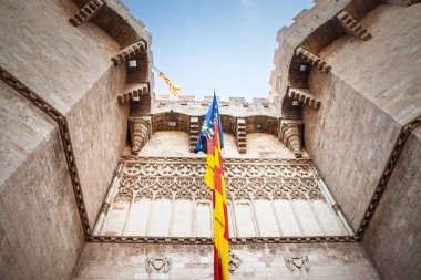 Valencia, İspanya 'daki tarihi Porta dels Serrans (Serranos Gate), ortaçağ mimarisi ve canlı bir Valencia bayrağı sergiliyor. Eski bir tahkimat ve Valencia 'nın ortaçağ kapısı..