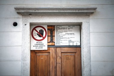 TRIESTE, ITALY - 17 Aralık 2024: İtalyan inşaat izni (Permesso di costruire) Trieste 'deki bir inşaat sahasında yayınlanan tebligat, yönetmeliklere uyulması ve güvenliğin sağlanması.