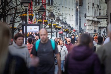 BELGRAD, SERBIA - 21 Mart 2025: Baba, kalabalık bir Knez Mihailova gezinti ortasında oğlunu omuzlarında taşır; seçici odak çerçeveli şehir içinde nesiller arası gezintiyi canlandırır.