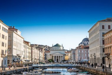 TRIESTE, ITALY - 17 Aralık 2024 Trieste Canal Grande ve Sant Antonio Taumaturgo Kilisesi 'nin rıhtımdaki pastel sarayı. Canal Grande Trieste 'nin eski kasabasında bir kanal, bir dönüm noktası.