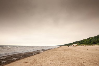 Dubulti 'deki Jurmala plajının (Jurmalas Pludmale) panoraması, yağmurlu bir öğleden sonra, baltık denizinde. Jurmala, Letonya 'nın Baltık devletlerinde bir tatil beldesidir..