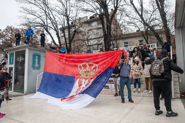 BELGRAD, SERBIA - 15 Mart 2025: Belgrad 'da protestocular,' Krvave su vam ruke ', Dinstaj veya Pumpaj olarak bilinen hükümet karşıtı protestolara karşı 15 Mart' ta Sırp bayrağı göndere çekiyorlar.