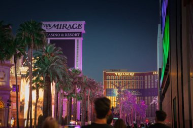 LAS VEGAS, 21 AĞUSTOS 2024: Yeni yıkanmış palmiyeler, Las Vegas Şeridi 'ndeki renkli LED' lerin altında kalabalık ve trafik darbesi altında Serap ve Hazine Adası cephelerine doğru ilerler..