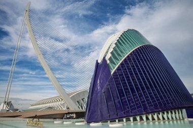VALENCIA, SPAIN - 13 Ekim 2024: Pont de lAssut de lOr kablo konaklama köprüsü Valencias Sanat ve Bilim Şehri 'ndeki derin mavi CaixaForum binasının yanında, Calatrava tasarım sergisi