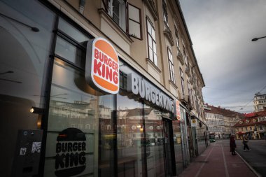 GRAZ, AUSTRIA - 17 Aralık 2024: Yeni tasarım Burger King logosu Graz vitrininde parlıyor. Burger King, tüm dünyaya yayılmış bir Amerikan fast food restoranıdır..