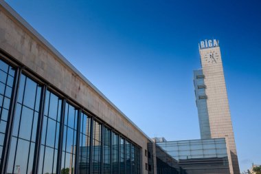 Riga Centrala Stadyumu 'nun ana perdesi uzun camlı salonu ve Baltık demiryolu yolcuları için önemli bir ulaşım merkezi olan ikonik saat kulesi. Riga, Letonya 'nın ana tren istasyonu.