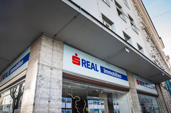 KLAGENFURT, AUSTRIA - 17 ДЕКАБРЯ 2024: Логотип S Real Immobilien, входящий в группу компаний Sparkasse (Erste group), доминирует в углу офиса недвижимости; недвижимость заполняет окно.