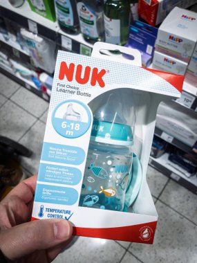 BELGRAD, SERBIA - 22 Mart 2025: Belgrad 'daki bir süpermarkette bebek eşyaları rafında Silikon ağzı, tutacakları ve sıcaklık kontrol ikonu bulunan İlk Seçmeli öğrenci şişesinin üzerinde Nuk' un Logosu (6-18 metre).