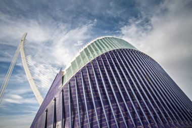 VALENCIA, SPAIN - 13 Ekim 2024: Pont de lAssut de lOr kablo konaklama köprüsü Valencias Sanat ve Bilim Şehri 'ndeki derin mavi CaixaForum binasının yanında, Calatrava tasarım sergisi
