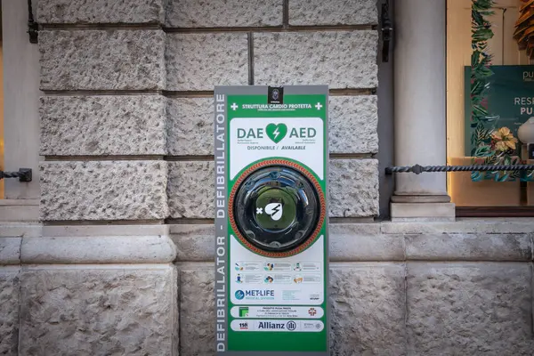 TRIESTE, ITALY - 17 Aralık 2024: Duvara monte edilmiş DAE / AED kabinesi, trieste caddesindeki sert taş işçiliğine karşı ayakta duran iki dilli, otomatik dış defibrilatöre kamu erişimi sağladı