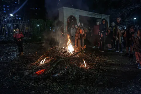 BELGRAD, SERBIA - 6 Ocak 2025: Ortodoks noeli sırasında Belgrad 'ın Banjica kentinde badnjak şubelerini yakan Sırp Halkı hakkında seçici bulanıklık. Badnjaci, Sırbistan 'da geleneksel bir Noel geleneğidir..