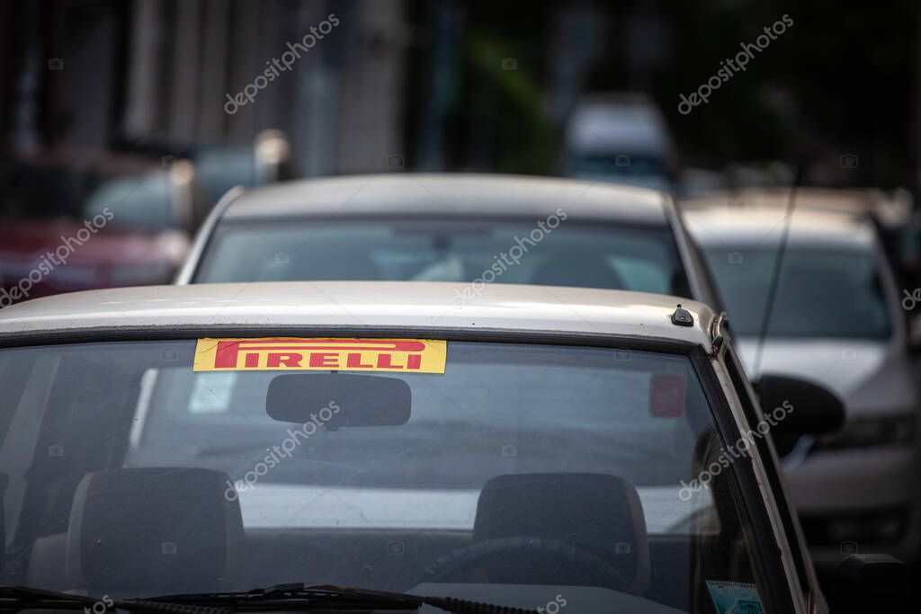 BELGRADE, SERBIA - MARCH 22, 2025: A yellow Pirelli windshield sticker on an aging compact car in Belgrade, Serbia. Pirelli is an italian tire maker.
