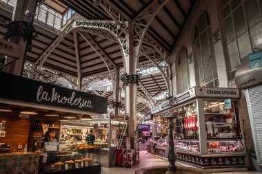 VALENCIA, SPAIN - 15 Nisan 2025: Mercat Central 'da satıcılar ve müşteriler bölgesel ürünlere bakıyorlar. Mercado merkezi veya Valencia merkez pazarı, kapalı bir pazardır..