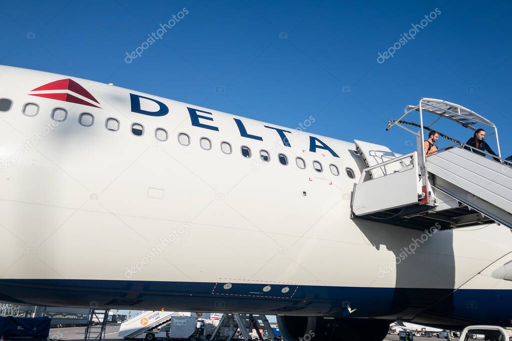 PARIS, FRANCE - AUGUST 26, 2024: Delta AirLines Airbus A330 on the apron at Charles de Gaulle Airport as passengers exit via mobile stairs, showing post-flight disembarkation and airline branding.