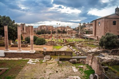 Roma Forumu 'nun (foro romano) geniş hava manzarası Roma' da ayakta duran sütunlar, dağınık taş kalıntıları ve Palatine Hill binaları ile antik sivil yaşamın kalbini resmediyor..