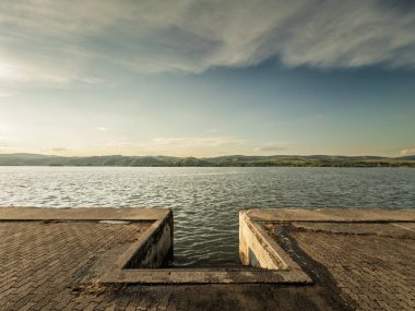 Sırbistan 'ın Veliko Gradiste kentindeki beton iskeleden gün batımında Sırbistan' ın Sırp sınırındaki geniş Tuna Nehri 'ne bakarak, Cerdap demir kapılarının başlangıcında geniş açılı bir görüş açısı.
