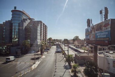 LAS VEGAS, 21 AĞUSTOS 2024: Las Vegas Bulvarı yakınlarındaki Elçilik Suitleri 'nin yakınındaki bir banliyö asfalt otoparkının manzarası yükseltilmiş, park halindeki arabalarla kaplı, sol ufuk çizgisini ışık altında tutan otel kulesi.