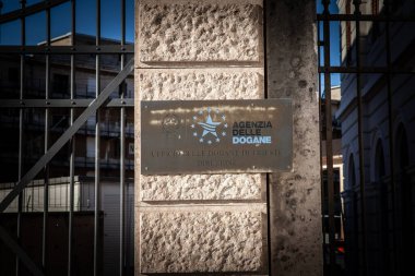 TRIESTE, ITALY - 17 Aralık 2024: Trieste Gümrük Dairesi 'nde taş bir sütuna yerleştirilen' Agenzia delle Dogane 'plaketi. Agenzia delle dogane e dei Monopoli İtalyan gümrük dairesi..