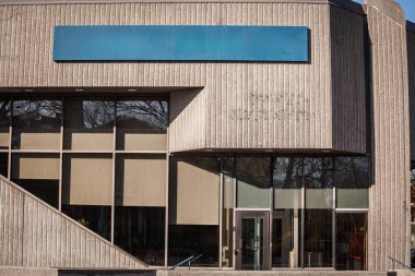Kuzey Amerika 'da güneşli bir kış sabahında boş bir tabela ile tırtıklı beton ofis bloğu boş duruyor. Yüzyıl ortası sert cepheleriyle kurumsal mimarinin yeniden kullanılmasını bekliyor..