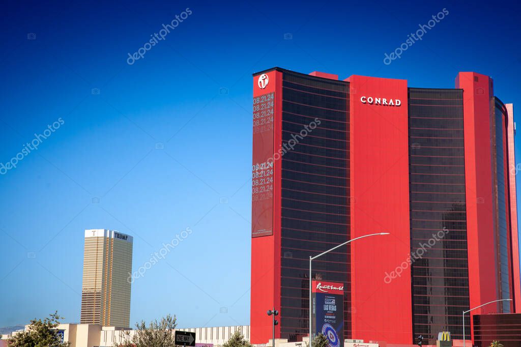 LAS VEGAS, AUGUST 21, 2024: The bold red Conrad tower at Resorts World Las Vegas rises against a clear desert sky. Part of the Conrad group, it's a casino and hotel resort on the strip.
