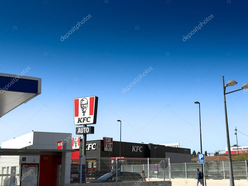 VALENCIA, SPAIN - APRIL 15, 2025: KFC drive-thru outlet in Valencia,, shows Colonel Sanders logo on roadside sign. Kentucky Fried Chicken is an American fast food restaurant chain