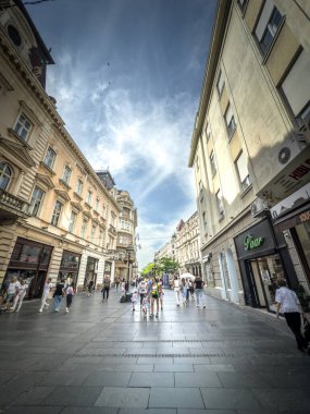 BELGRAD, SERBIA - 22 Nisan 2025: Yayalar, Belgrad 'ın ana yaya sokağı olan Kneza Mihailova, Sırbistan' da 19. yüzyıl cepheleriyle çevrili bir alışveriş caddesi boyunca güneşli bir yürüyüş yapıyorlar.