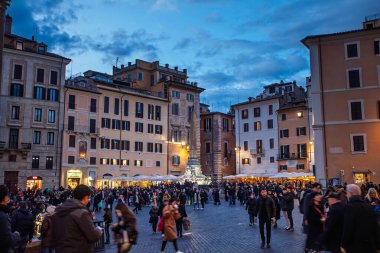 ROME, ITALY - 15 HAZİRAN 2025: Akşam kalabalığı Roma Piazza della Rotonda 'yı doldurdu, Pantheon' un kaldırımlı meydanı, tarihi cephelerin altında kafeler parlıyor ve alacakaranlıkta dikilitaşlı bir çeşme duruyor