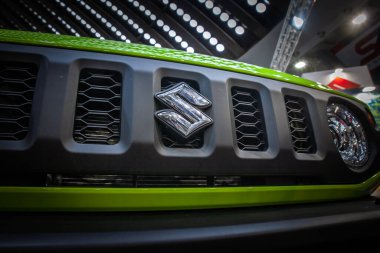 BELGRAD, SERBIA - 22 Nisan 2025: Suzuki logosu, Belgrad 'daki galerilerinde bulunan yeşil bir Suzuki SUV' nin ızgara bölümünde. Suzuki Motor Corporation bir Japon otomobil ve otomotiv üreticisi..