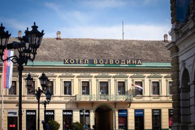 NOVI SAD, SERBIA - 12 Mayıs 2025: Trg slobode Meydanı 'ndaki Voyvodina Oteli' nin neoklasik cephesi, Novi Sad, Sırbistan, Kiril alfabesi şeklinde bir çatı işareti, Novi hüzünlü turizminin sembolü.