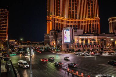 LAS VEGAS, 21 AĞUSTOS 2024: Las Vegas Strip, Nevada 'daki aydınlık Palazzo cephesinden gece trafiği hızla geçiyor; araçlar geniş bir kavşağı geçerken uzun süreli ışık yolları oluşturuyor.