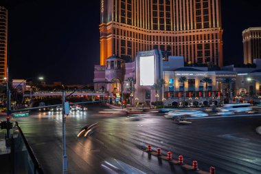LAS VEGAS, 21 AĞUSTOS 2024: Gece trafiği Las Vegas Bulvarı 'nda Palazzo ve Grand Canal Shoppes' in kesişiminde yoğun bir kavşak çiziyor. Uzun pozlama hız bulanıklığını, sinyalleri ve tatil beldelerini yakalar.