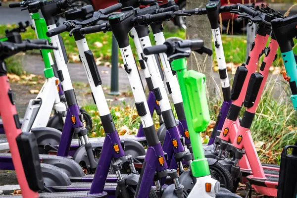 Dusseldorf, Almanya 'da bir caddeye park etmiş renkli limansız elektrikli scooter' ları kapatın, modern paylaşılan mikro hareketlilik ve çevre dostu kentsel taşımacılık.