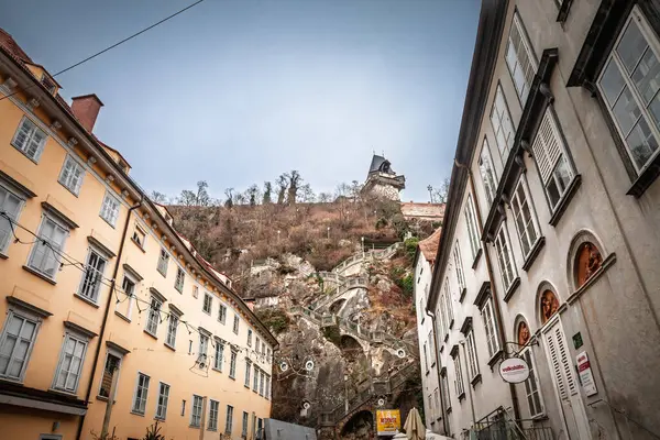 GRAZ, AUSTRIA - 17 ARALIK 2024: Schlossbergstiege 'e doğru bakan merdiven Schlossberg' e tırmanan ve Graz 'ın ana sembolü olan saat kulesi.