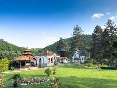 Sırbistan 'ın Valthe kenti yakınlarındaki Celije Manastırı' nın panoramik alanları. Çim, çardak, ahşap çan kulesi ve beyaz şapel ormanlık tepelerin arasında oturur, Manastir Celije bir Sırp ortodoks manastırı..