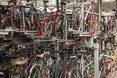 GRAZ, AUSTRIA - 17 ARALIK 2024: Graz, Avusturya 'da çok katlı bir bisiklet park tesisini park etmiş durumda. Çerçeveleri yoğun raflar tutuyor, günlük şehir hareketliliğini ve bisiklet kültürünü gösteriyor.