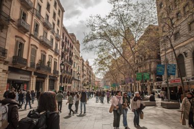BARCELONA, SPAIN - 5 Nisan 2025: Barcelona 'da Las Ramblas boyunca kalabalık, tarihi binaları olan bir yaya bulvarı. Sahnede turistler ve yerliler Katalan başkentinde gezinti alanlarını paylaşıyorlar.