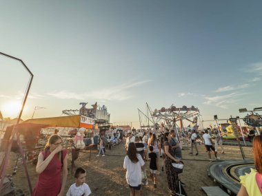 GROCKA, SERBIA - 2 AĞUSTOS 2025: İnsanlar Grocanski Vasar veya Grocanske svecanosti 'de gün batımında gezintiye çıkıyorlar. Aile eğlenceleri, oyunlar ve satıcılarla dolu canlı bir panayır..