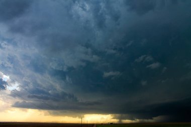 Tozlu bir köy yolu, altında bir kasırga olan uğursuz bir fırtınaya götürür..