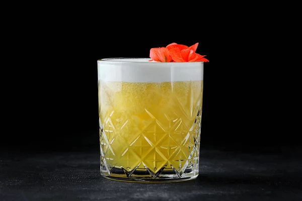Mango delight whiskey cocktail in an old-fashioned glass on dark concrete