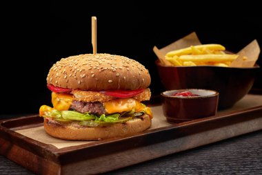 Duble köfteli hamburger, peynir, domates ve patates kızartması.
