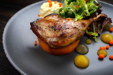 Ot, balkabağı ve sosla pişirilmiş ördek bacağı.