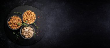 Tuzlu fındık, fıstık ve fıstık, bira için, koyu bir arka planda.