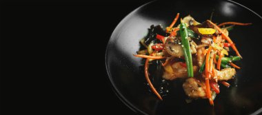 Mantar ve sebzeli Çin usulü tavuk, koyu bir arka planda. Panasia