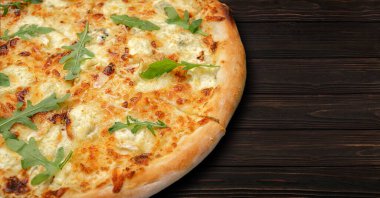 Dört peynirli pizza quattro fromaggi roka yapraklı gri beton üzerinde ahşap bir tahta üzerinde
