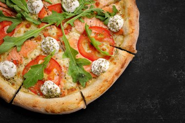 Somon, domates, peynir ve baharatlı pizza.