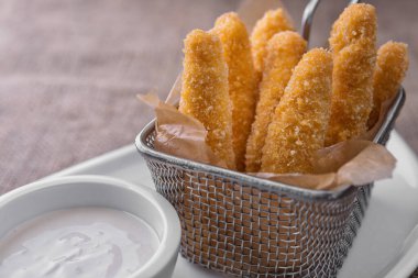 Soslu tavuk nuggetları beyaz tabakta, çuval bezinde