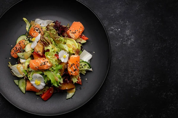 Somon ve salata karışımlı salata, tabakta, koyu betonda.